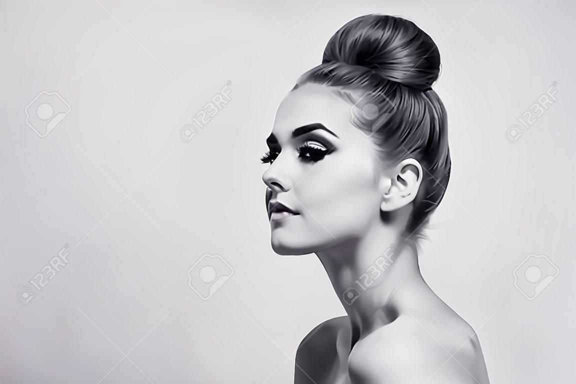 Черно-белый снимок молодой красивой девушки с волосами булочки