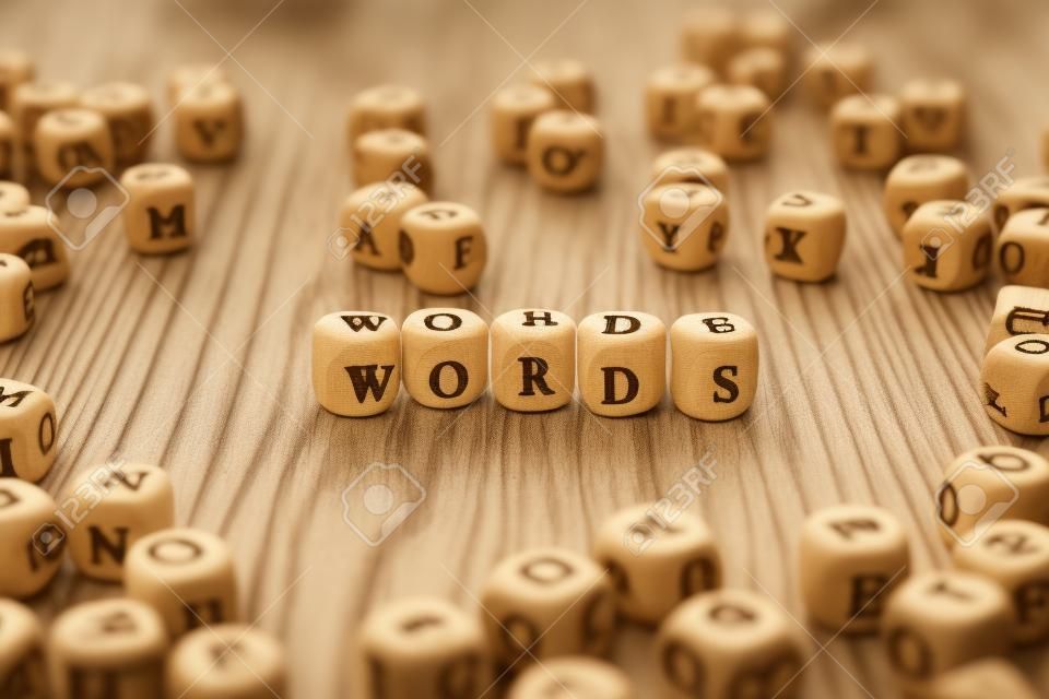 Word made with block wood letter next to a pile of other letters over the wooden board surface composition. Block ABC.