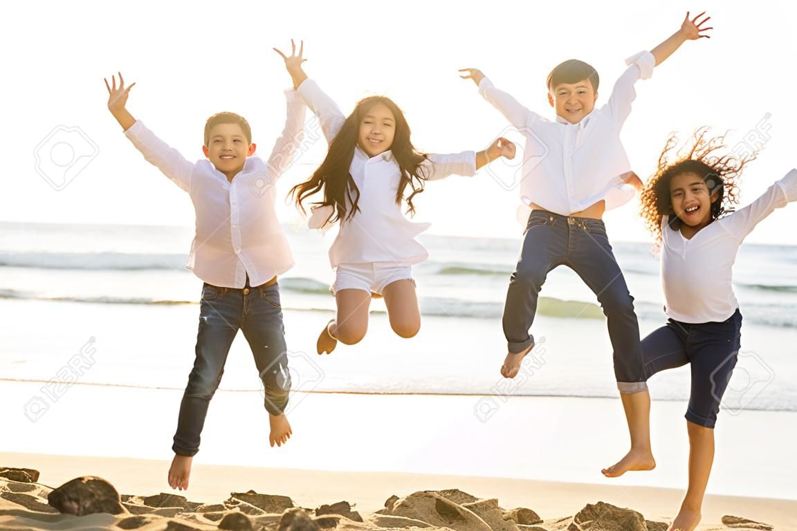Enfants heureux sautant avec la lumière du soleil sur la plage