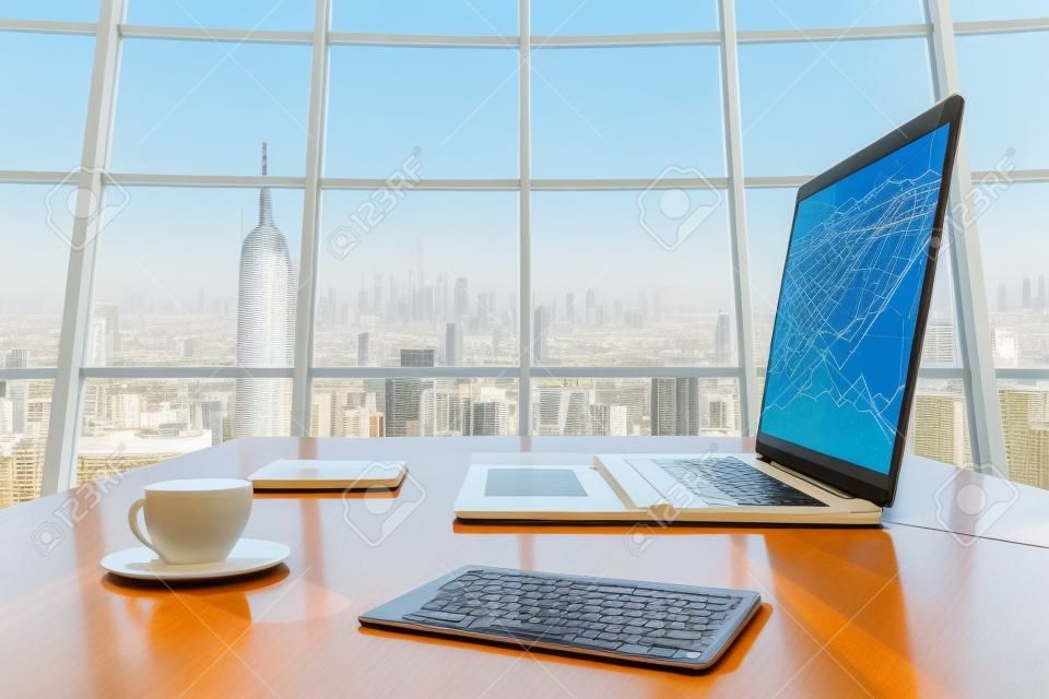 Soleggiato ufficio con vista megalopoli della città, tavoletta digitale e schermo del computer portatile con il diagramma di affari sul tavolo di legno