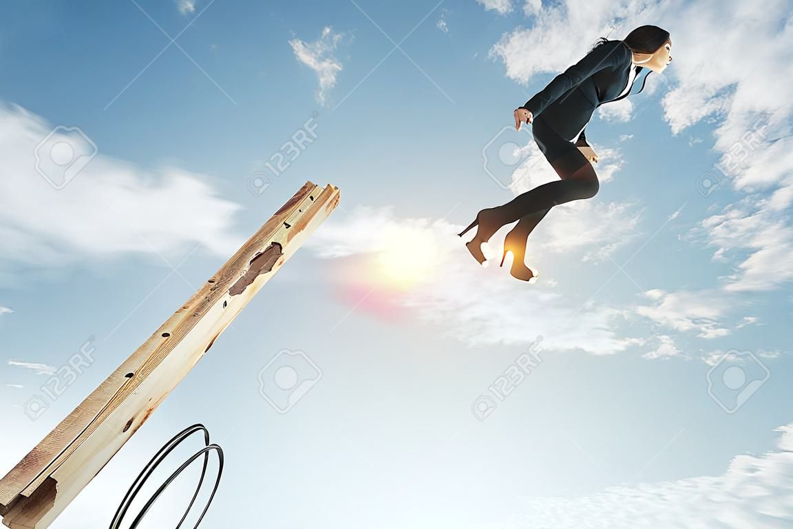 Businesswoman lauching off big spring on sky background with clouds. Startup and success concept