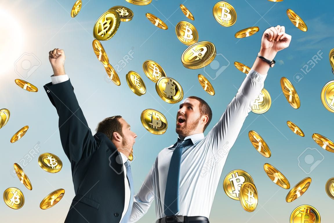 Uomo d'affari che celebra la pioggia bitcoin dorata sullo sfondo del cielo. Criptovaluta e concetto di successo