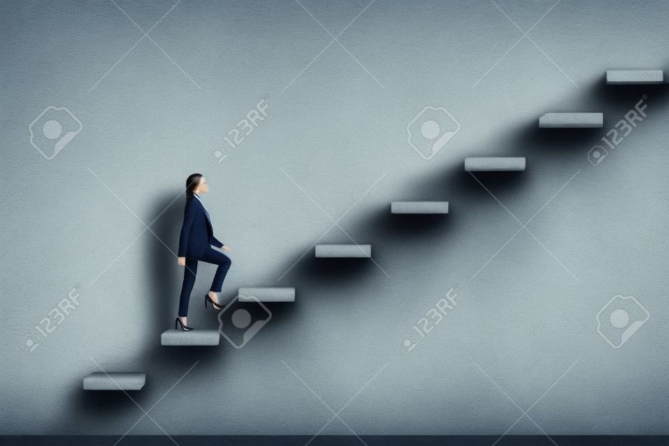Side view of young businesswoman climbing stairs to success on concrete wall background. Leadership and career development concept