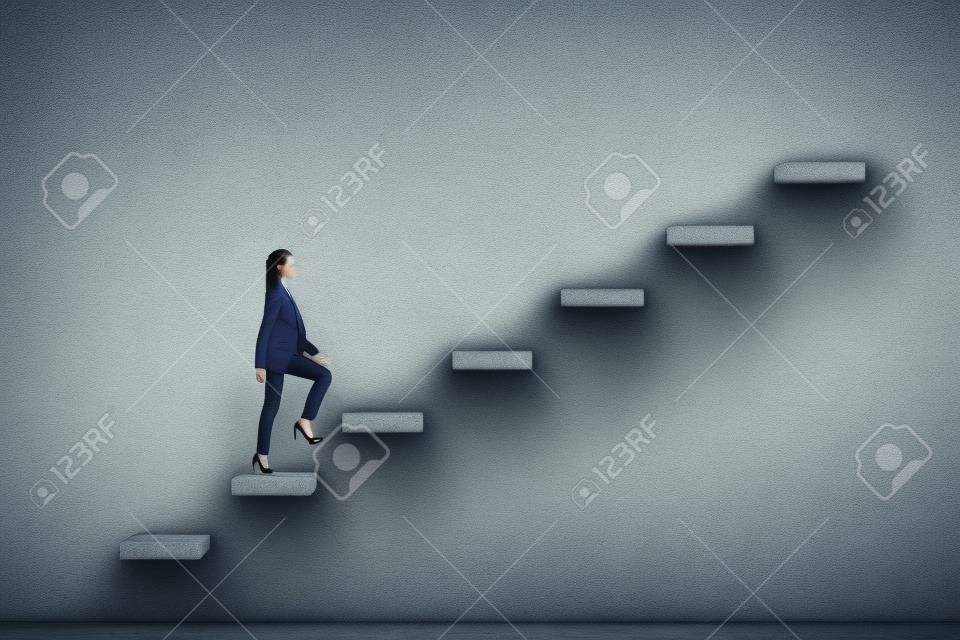 Side view of young businesswoman climbing stairs to success on concrete wall background. Leadership and career development concept