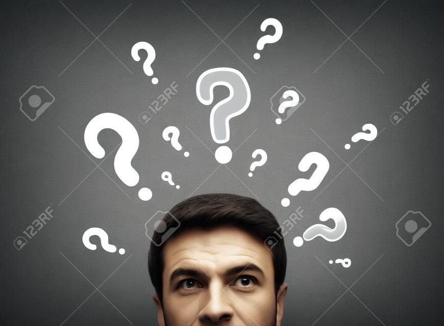 man with questions symbol on gray background