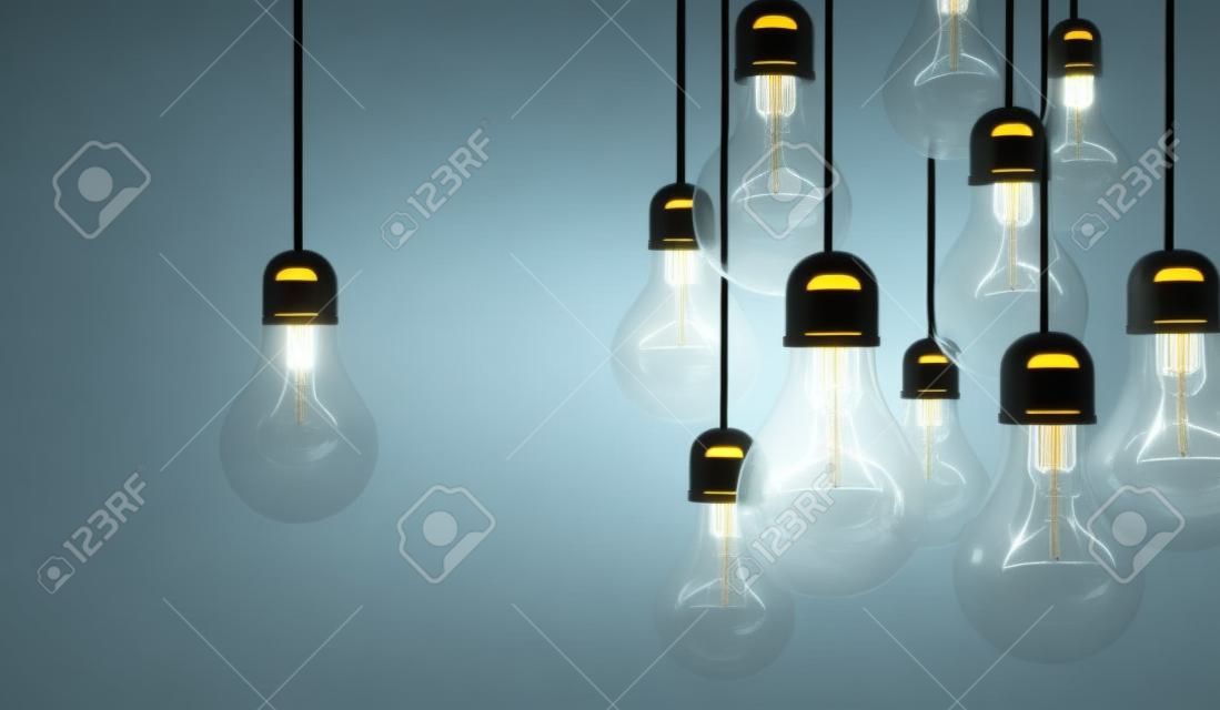 lâmpadas que penduram o fio e um brilha. Conceito da ideia do negócio.