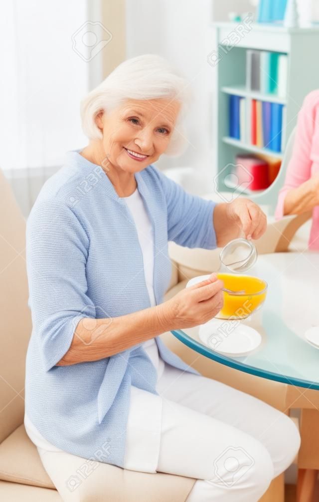 Attractive elderly woman eating breakfast.