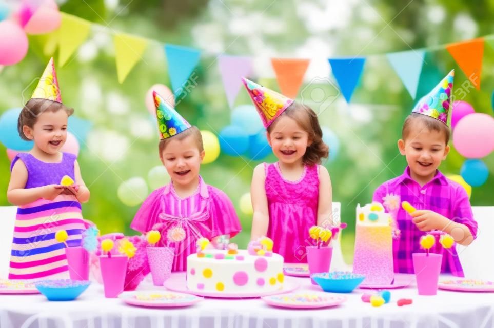 Kültéri születésnapi party a kisgyermekek színes torta