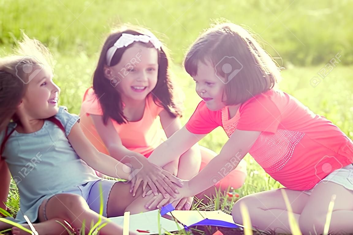 Группа счастливых детей, играющих на зеленой траве
