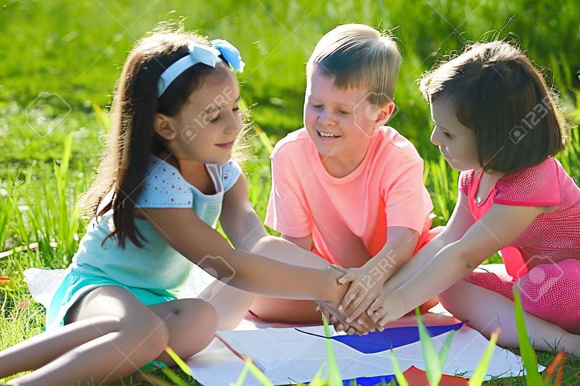 Groep van gelukkige kinderen spelen op groen gras