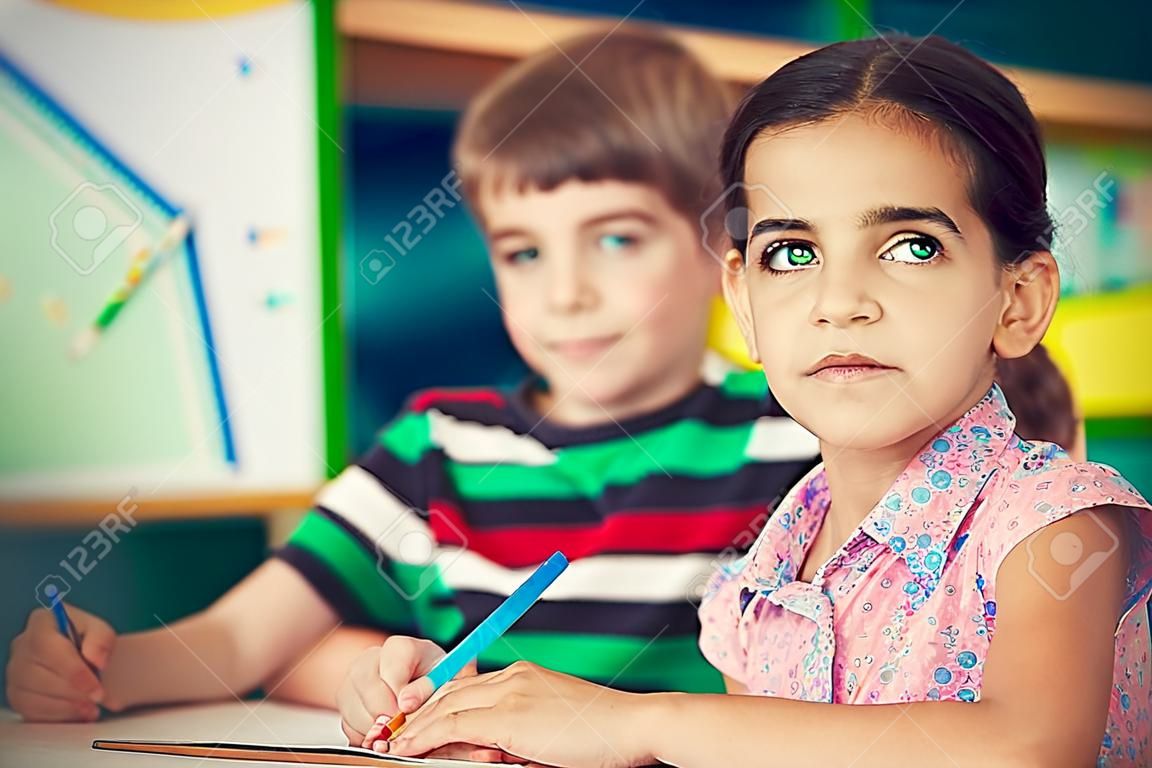 Красивая маленькая девочка и ее одноклассник в школе