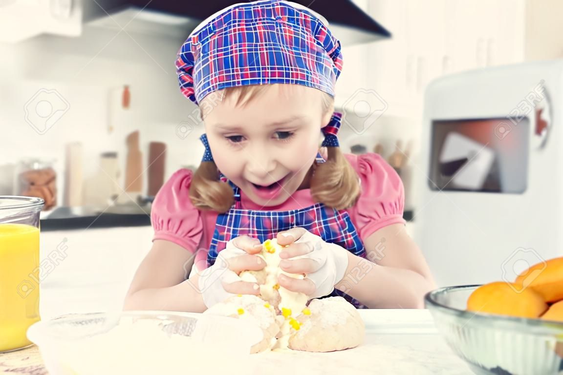 Schattig klein meisje in schort bakken koekjes thuis keuken