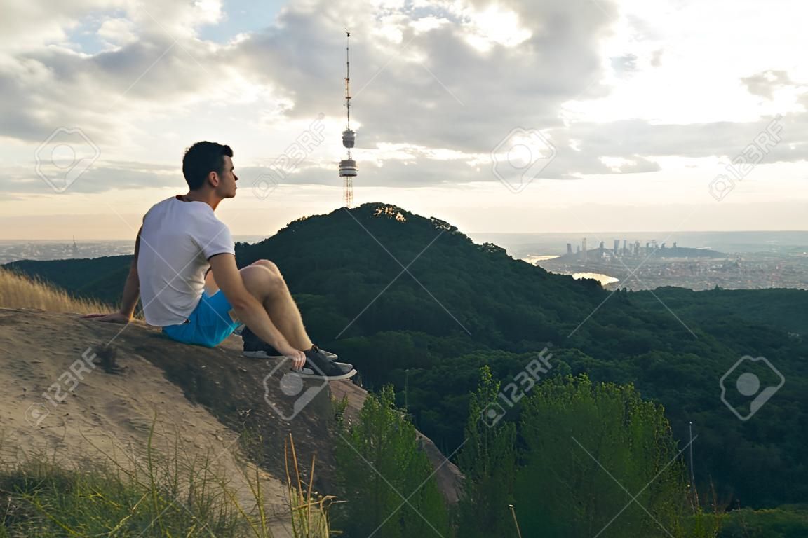 man sitting on the peak alone with his minds
