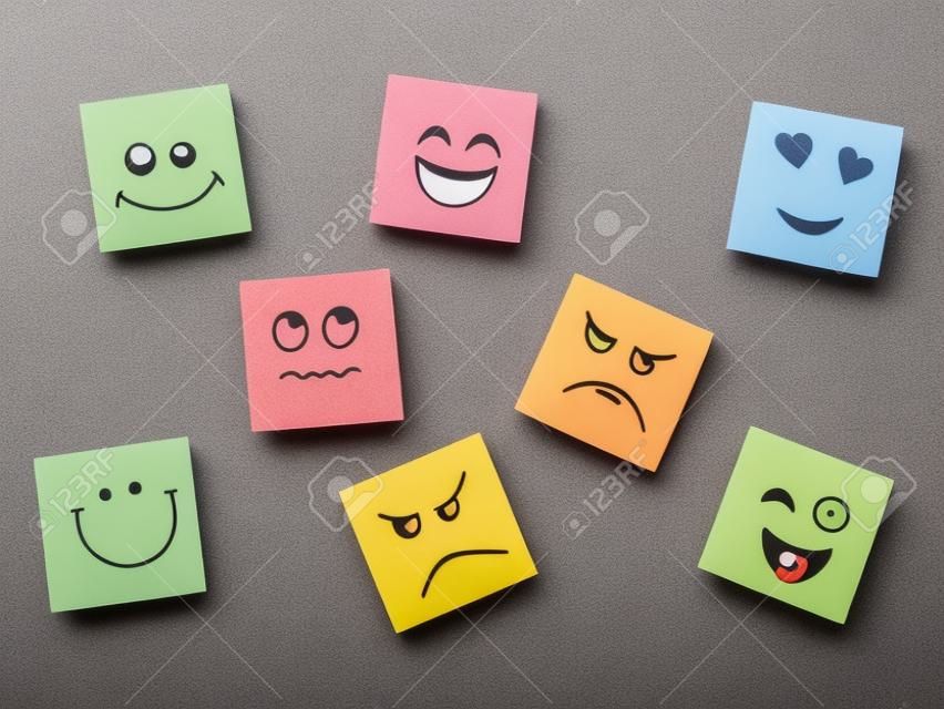 placa de cortiça com notas auto-adesivas coloridas representando vários emoticons com várias emoções conceito de comunicação