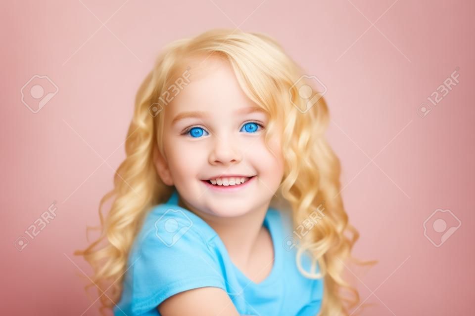 美しい幸せな黄金のブロンドの髪と青い目の若い女の子の顔の笑みを浮かべて、分離しました。