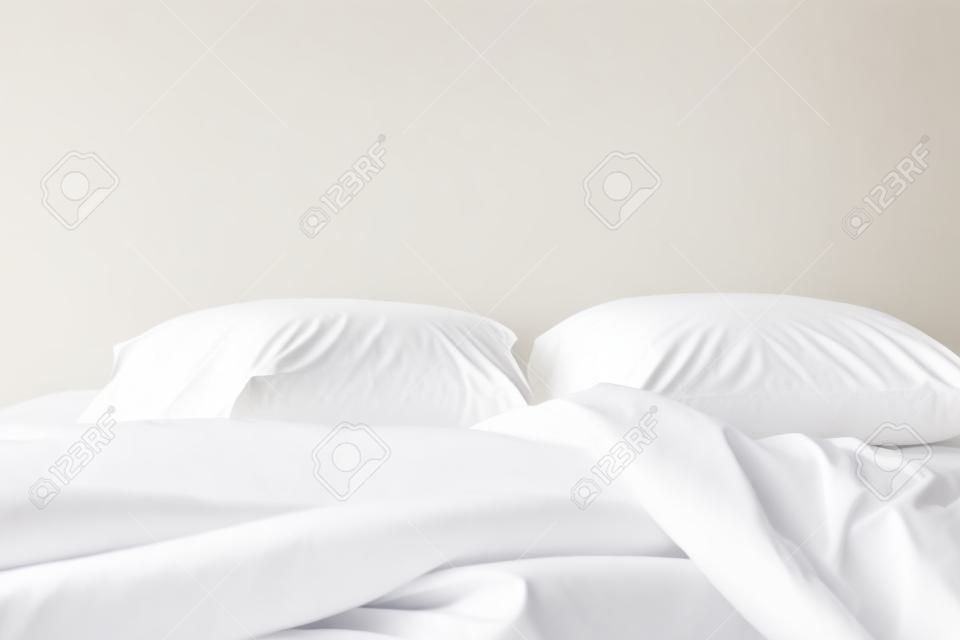 흰색 배경에 고립 된 흰색 침대 시트와 베개를 닫습니다
