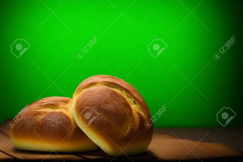 Close up two of bread on wooden table with green blur light background. Food concept