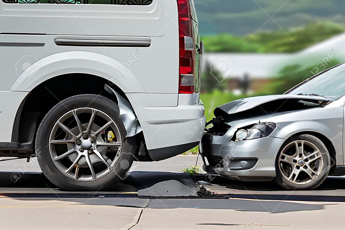 Car accident involving two cars on the road. Back side of van and front of siver car get damaged by accident. For car repair concept