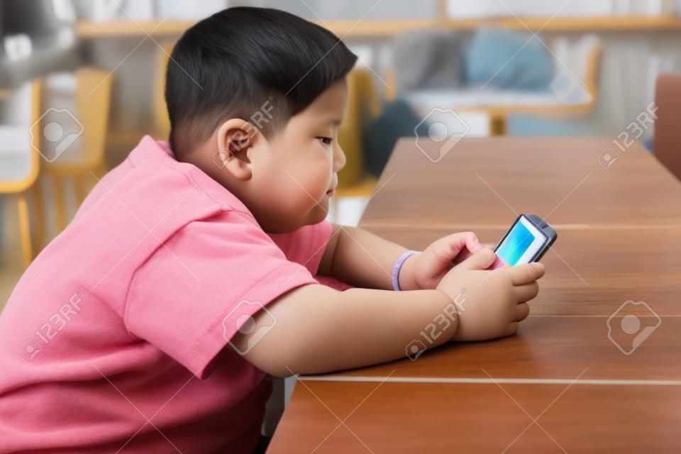 Aziatisch kind Jongen zijn verslavend spelen tablet en mobiele telefoons, Game Addiction