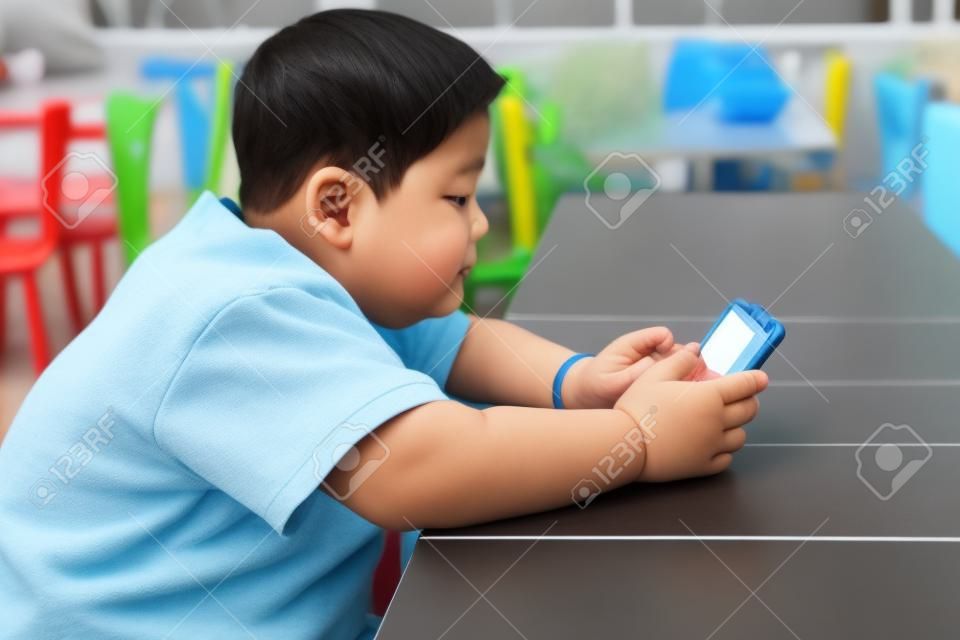 Aziatisch kind Jongen zijn verslavend spelen tablet en mobiele telefoons, Game Addiction
