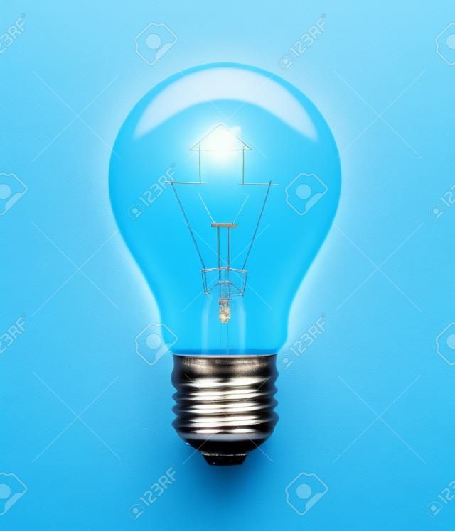 Light bulb with filament forming a house icon on blue background