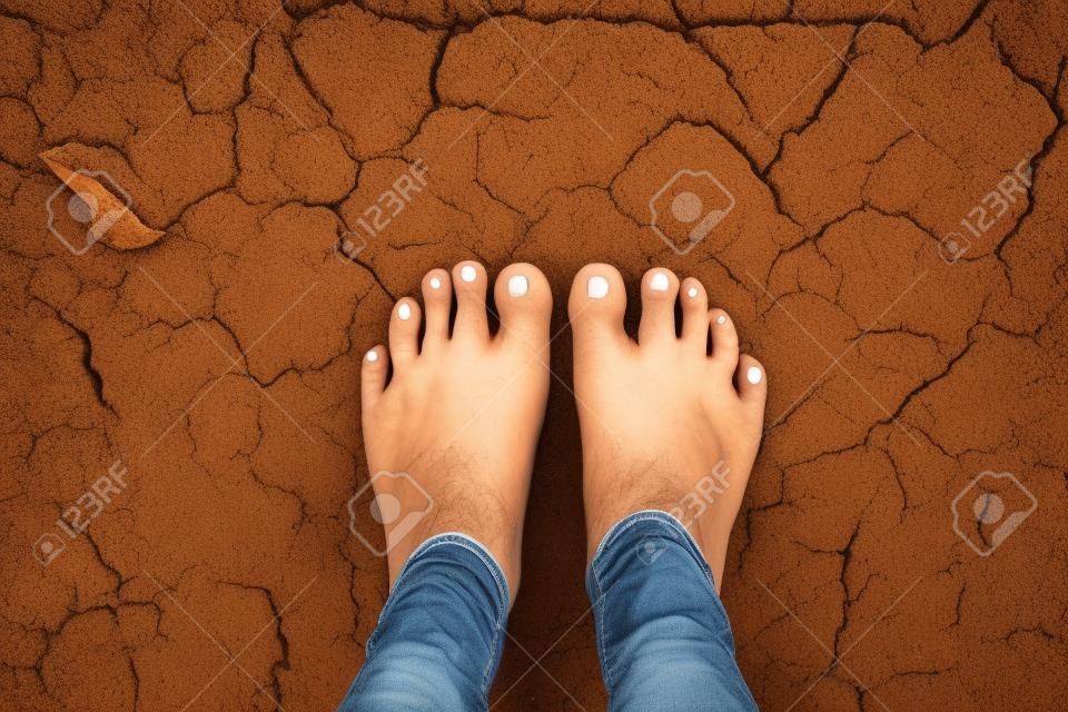 Selfie stóp z popękaną suchą ziemią