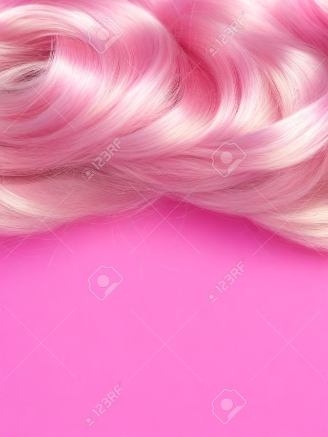 Peluca de pelo sobre fondo rosa