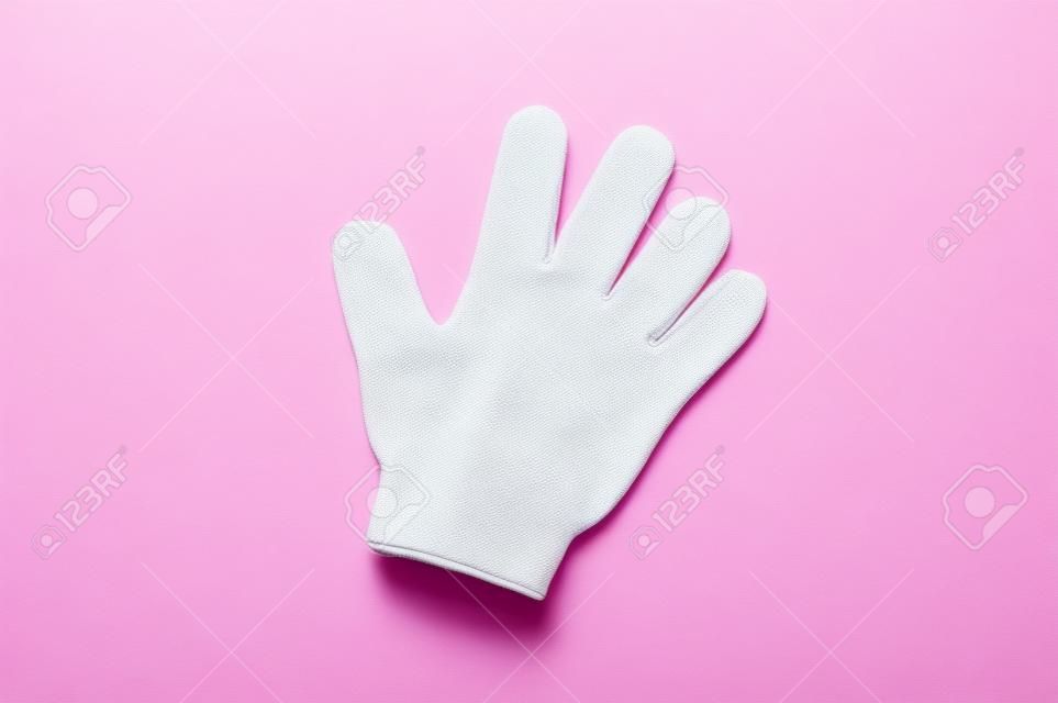 Vrouw exfoliating hydro handschoen op roze achtergrond. Massage en scrub. Gezondheid, spa en schoonheid concept