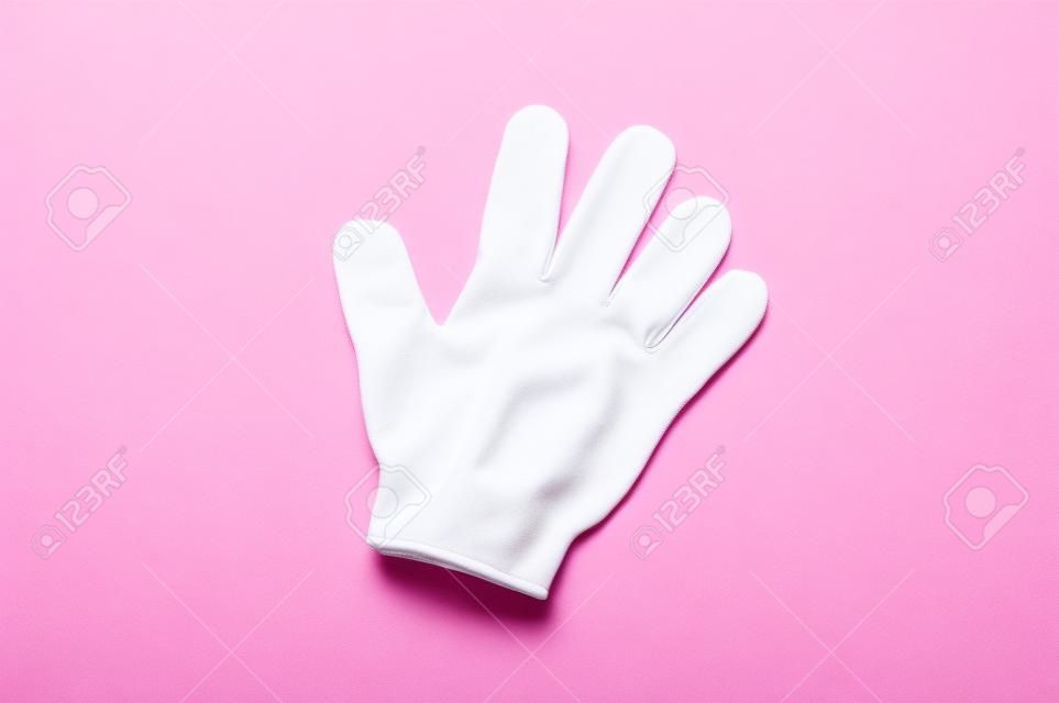 Vrouw exfoliating hydro handschoen op roze achtergrond. Massage en scrub. Gezondheid, spa en schoonheid concept