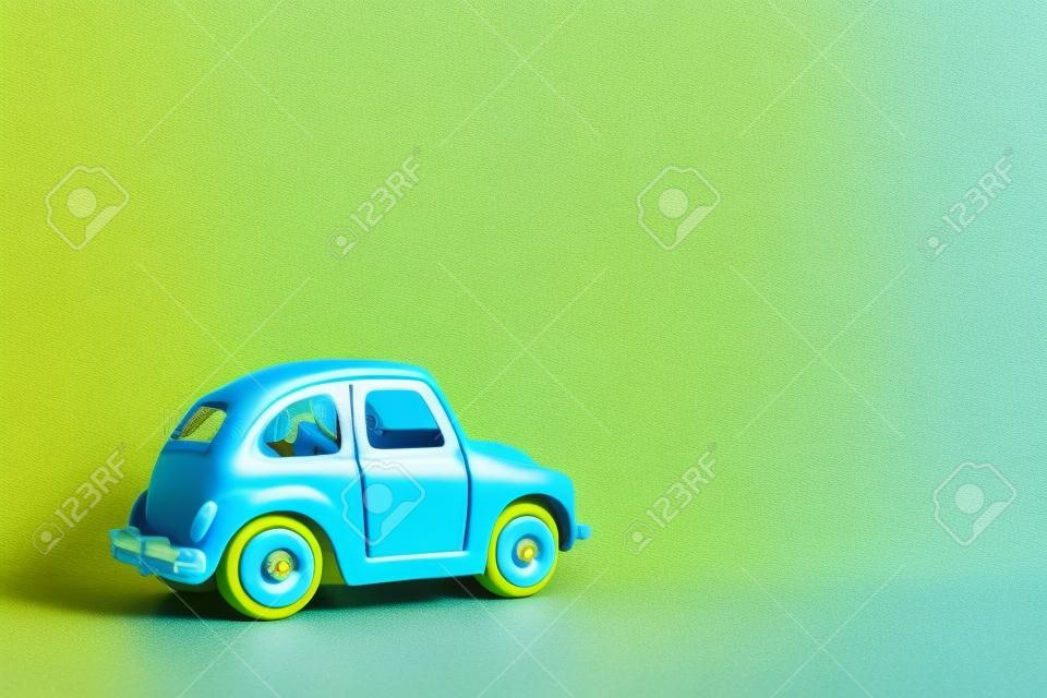 Omsk, Russia - May 26, 2019: Blue retro toy car on yellow background. Valentines day. Flower delivery. 8 March, International Happy Womens Day. Summer travel concept. Taxi