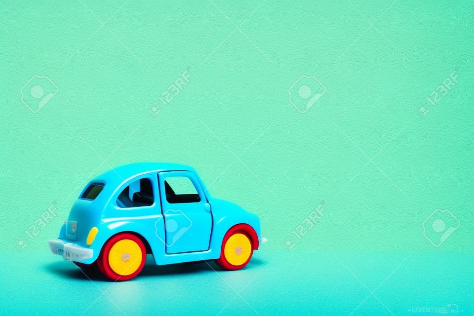 Omsk, Russland - 26. Mai 2019: Blaues Retro-Spielzeugauto auf gelbem Hintergrund. Valentinstag. Blumenlieferdienst. 8. März, Internationaler Tag der glücklichen Frauen. Sommerreisekonzept. Taxi