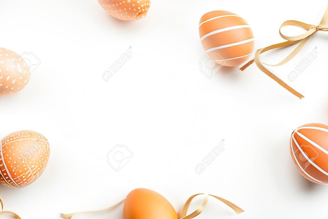 Happy Easter concept. Frame of elegant Easter eggs on white background. Flat lay, top view, copy space.