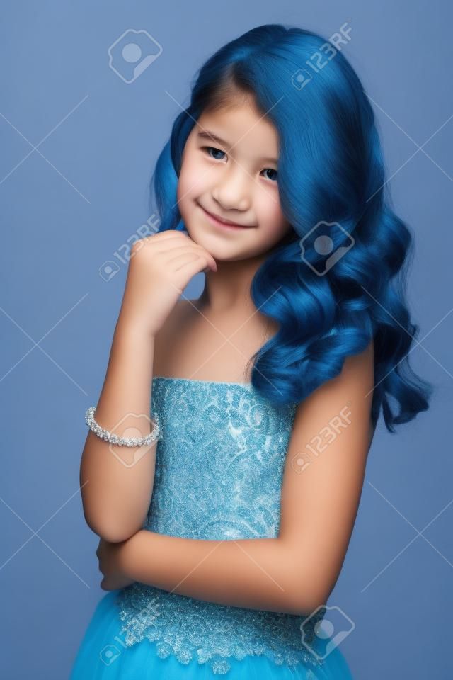 Pre-teen dziewczyna z pięknymi włosami w niebieskiej sukience.