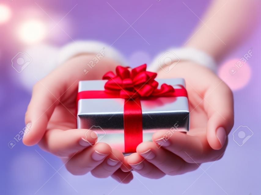 Hands holding bella scatola regalo, femmina regali, vacanze di Natale e il concetto stagione saluto, dof poco profondo