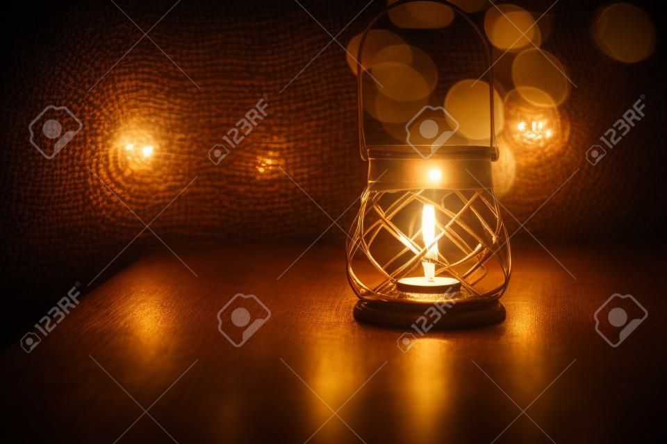 Hermoso candelabro vintage sobre fondo de luces borrosas, decoración acogedora en el interior del restaurante, ambiente romántico a la luz de las velas