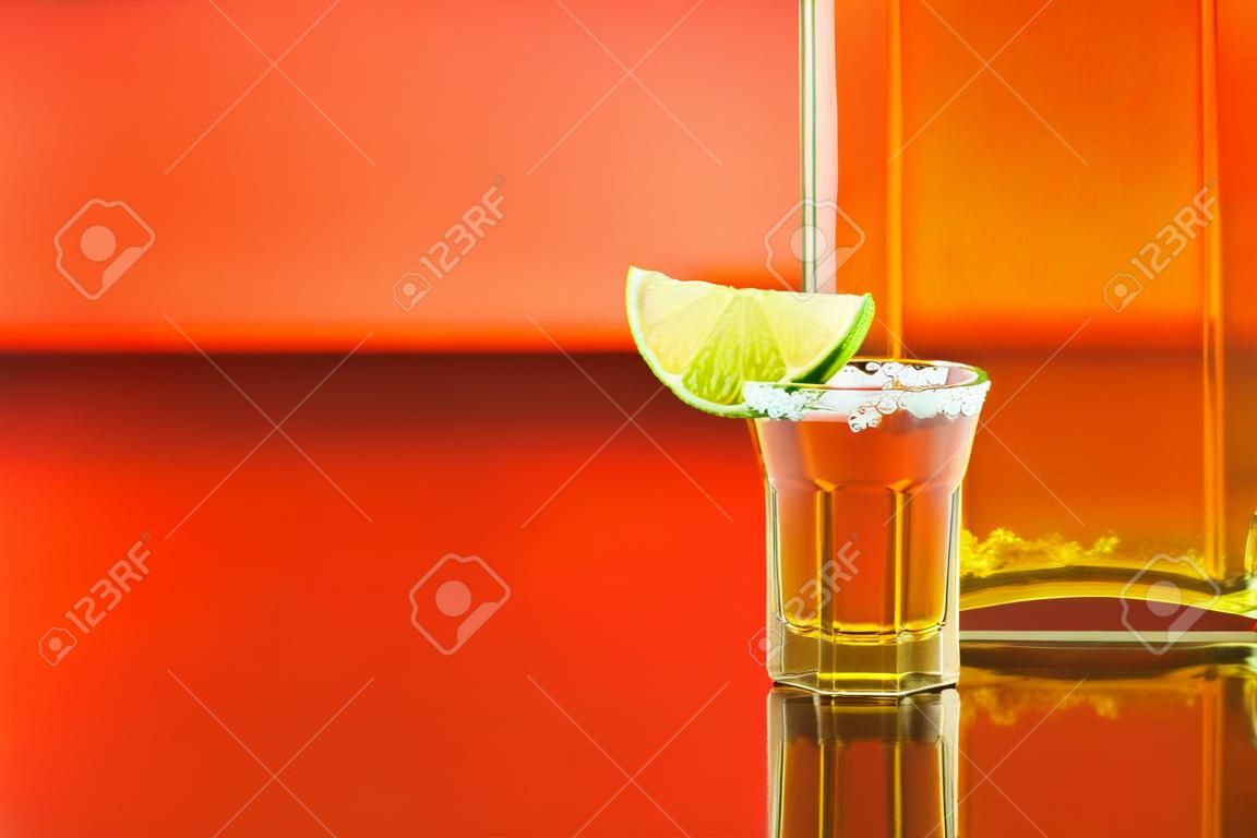 Lime on glass with salt and a bottle of tequila. Background with copy space