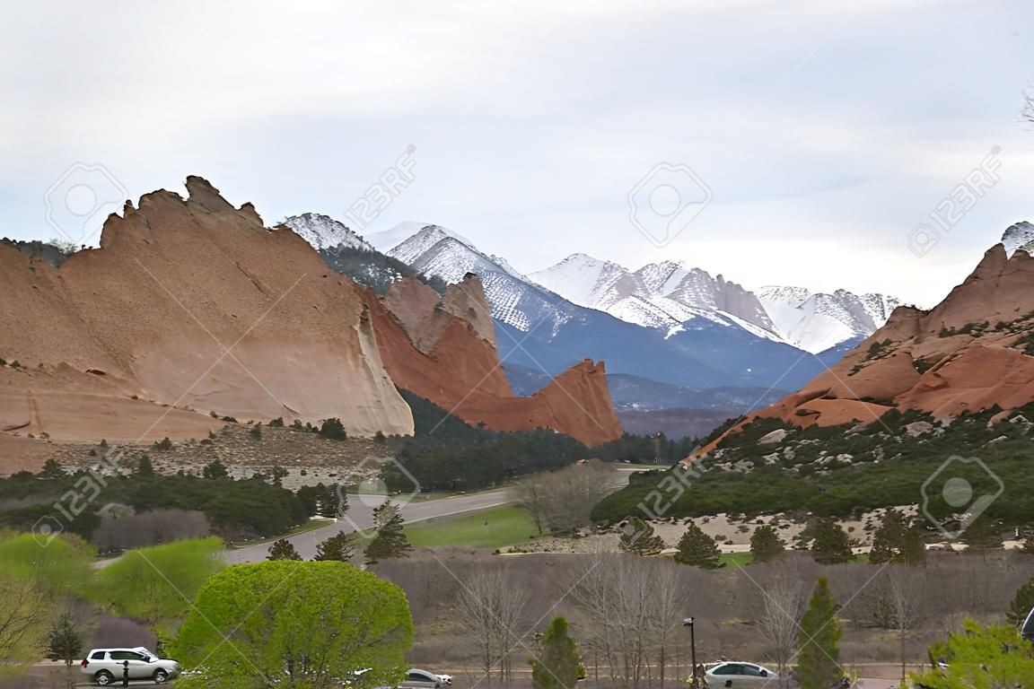 The beautiful sandstone rock formations of Garden of the Gods near Colorado Springs, Colorado stand out amongst the new leaves of Spring on surrounding trees.  The entrance to the public park is marked by mirrored flagstone signs and sets a nice introduct