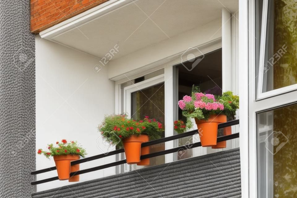 Balkon mit Blumen in Töpfen dekoriert, typischer europäischer Balkon in Berlin, Deutschland