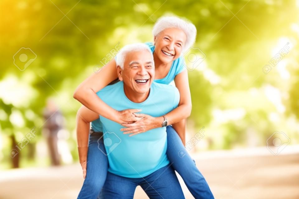 Sorridente coppia senior attiva divertendosi insieme nel parco