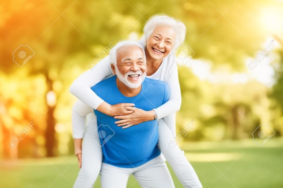 Sonriente pareja senior activa divirtiéndose juntos en el parque