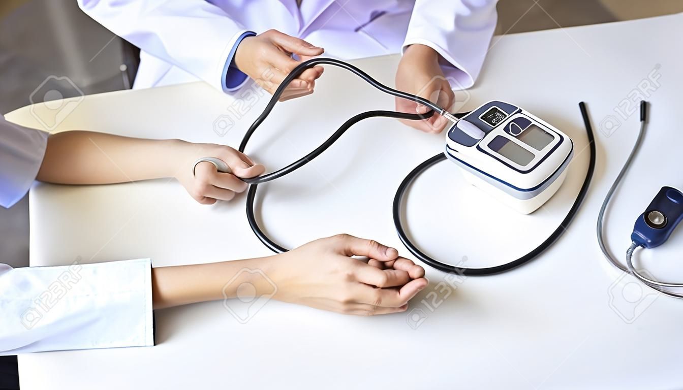 Medico che misura la pressione sanguigna del paziente in clinica o in ospedale. Concetto medico e sanitario.