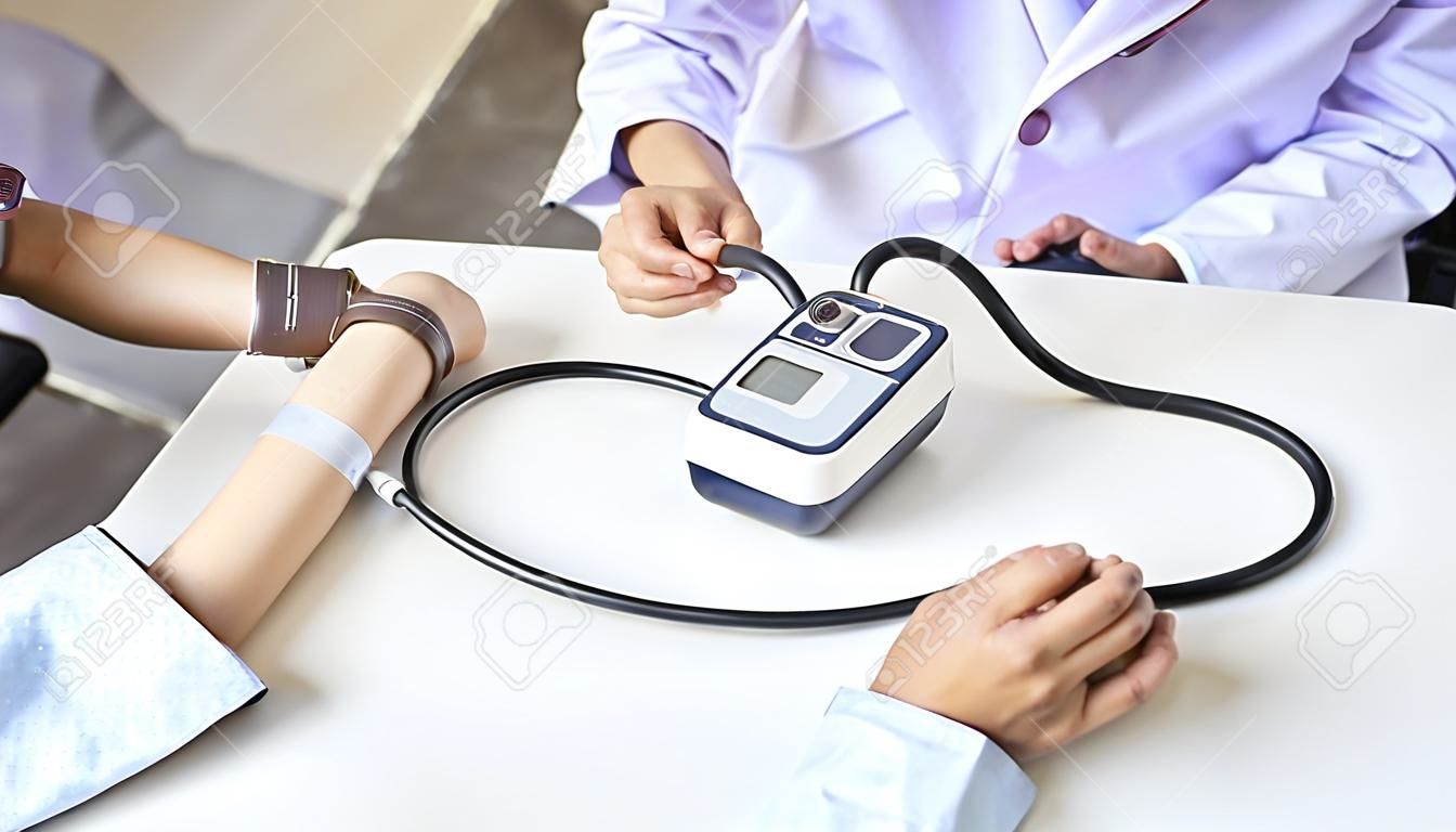 Medico che misura la pressione sanguigna del paziente in clinica o in ospedale. Concetto medico e sanitario.