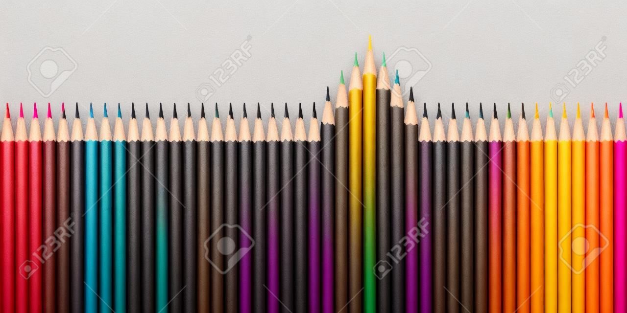Koncepcja śmiałych i nowych pomysłów z rzędem czarnych ołówków, z których wyłaniają się kolory, aby zaznaczyć ich różnicę.