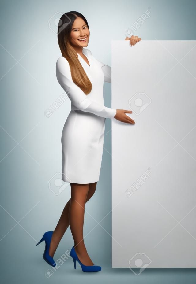 Женщина, стоя рядом с большой белый плакат