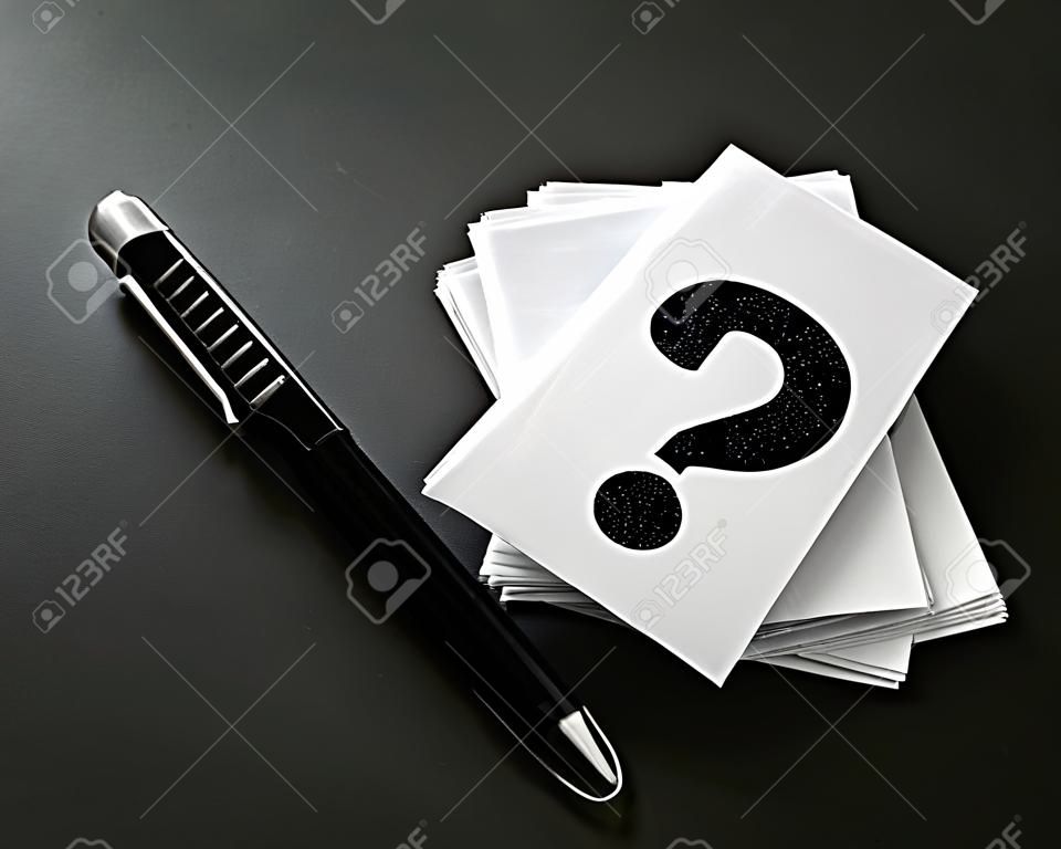 apilamiento de tarjeta de visita blanca con símbolo de signo de interrogación escrito sobre fondo negro, preguntas y respuestas o diseño de concepto de preguntas y respuestas