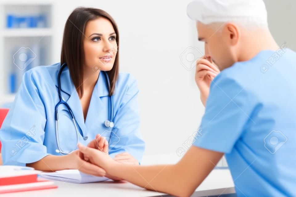 Ärztin spricht und untersucht männlichen Patienten im Krankenhausbüro. Gesundheitswesen und medizinischer Dienst.
