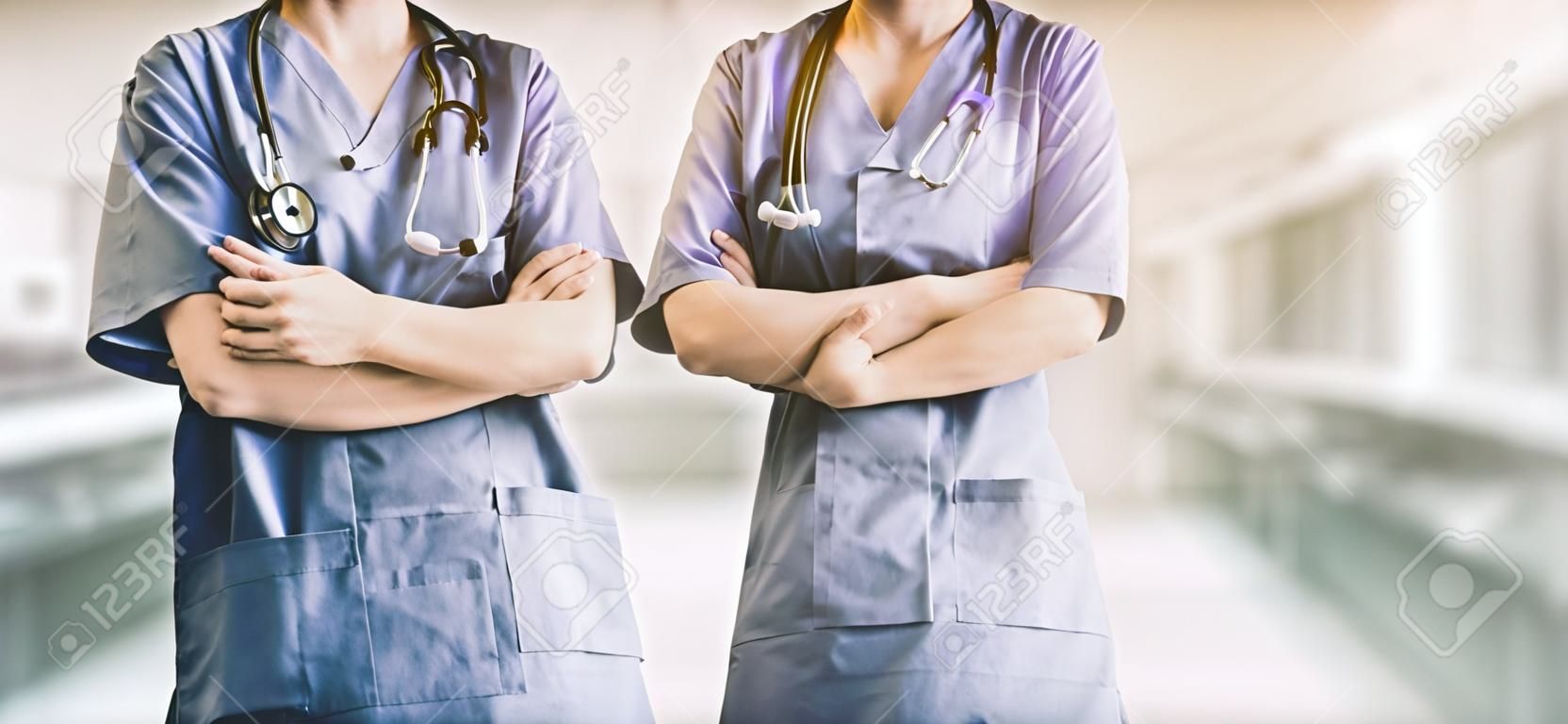 Deux membres du personnel hospitalier - chirurgien, médecin ou infirmière debout avec les bras croisés à l'hôpital. Soins médicaux et service médical.