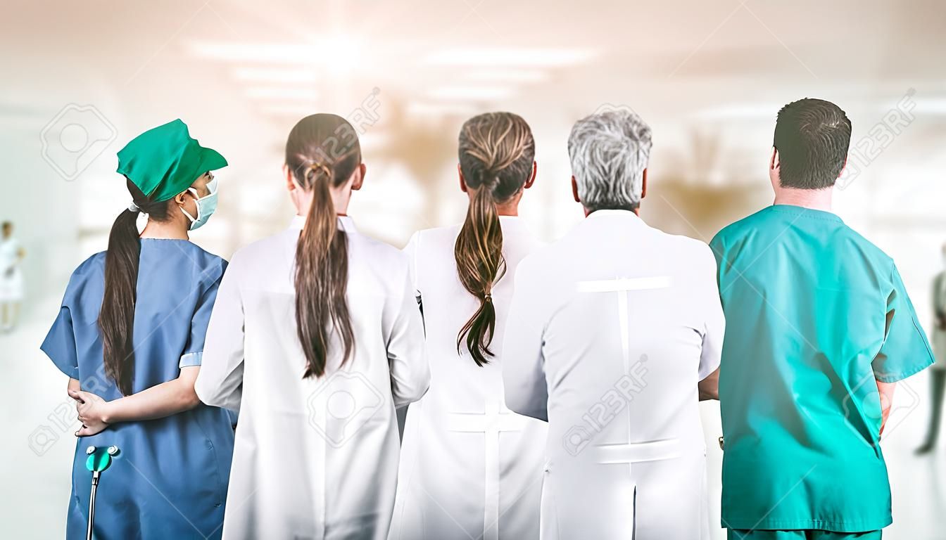 Koncepcja pracy zespołowej i obsługi lekarza w służbie zdrowia - międzynarodowa grupa personelu medycznego składająca się z lekarzy, pielęgniarek i specjalistów chirurgów stojących ze stetoskopami w szpitalu.