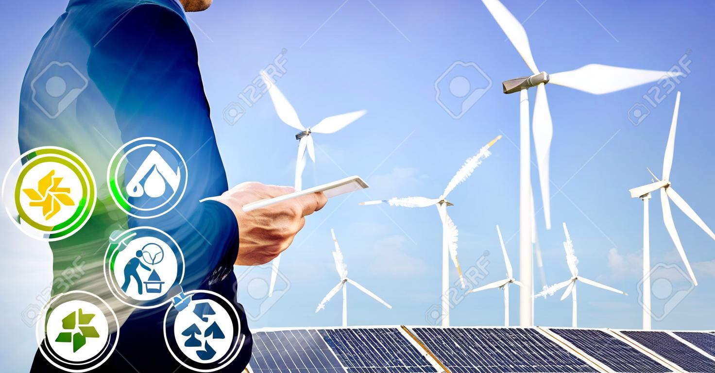 Double exposure graphic of business people working over wind turbine farm and green renewable energy worker interface. Concept of sustainability development by alternative energy.