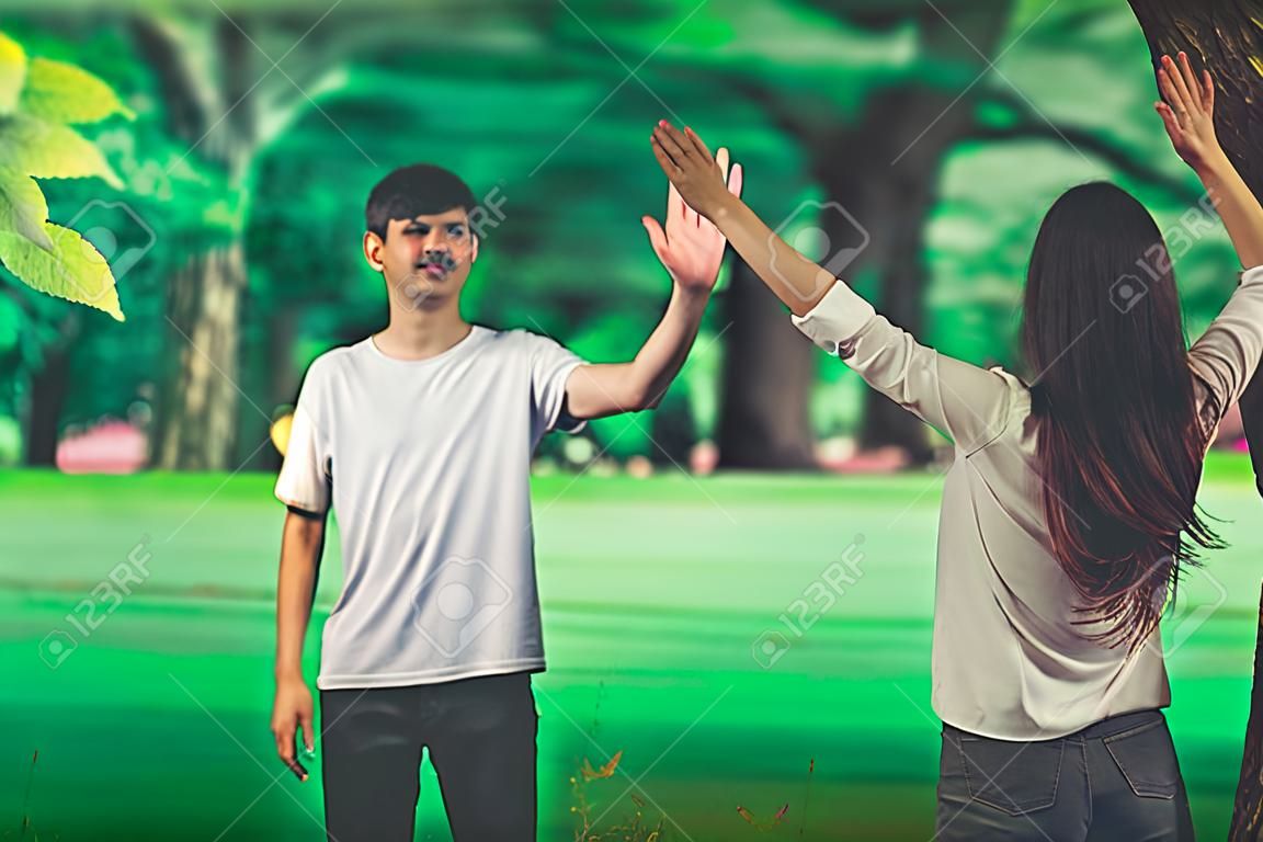 Jovens, homem e mulher cumprimentando ou dizendo adeus acenando com as mãos no parque.